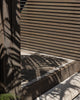 An entranceway with a doormat made with natural dark jute fibres by Baya. 