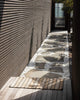 A sunny entryway with a striped jute entrance mat, made by Baya. 