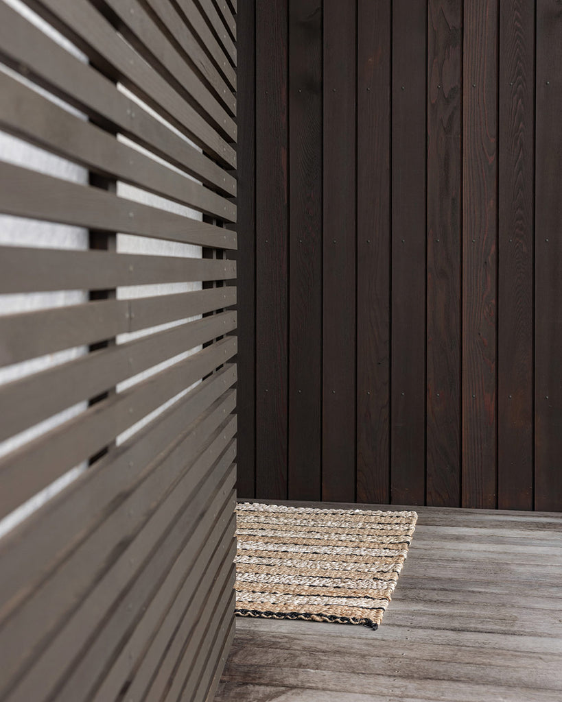 An entranceway with a gorgeous natural fibre striped handwoven jute doormat, by Baya. 