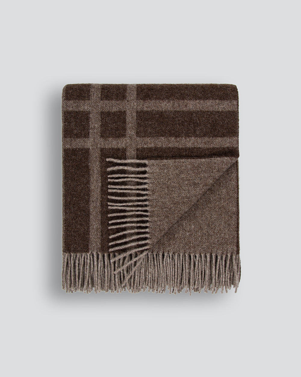 Brown modern plaid wool blanket with fringe on a light gray background