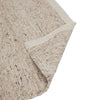 Close up of the corner of a textural woolen rug, in shades of cream, honey brown and light beige, with subtle colour shifts by Soren Liv NZ and Globe West. The edge of the rug is flipped up to show the underside. 