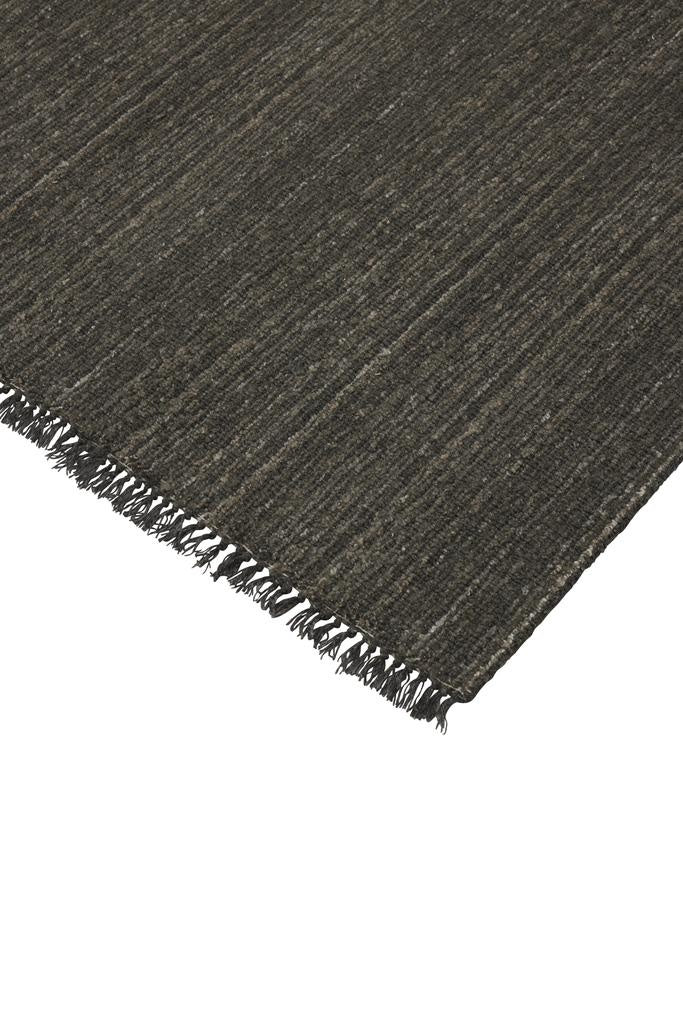 The 'Puglia' floor rug by Weave Home, in colour 'Pigeon" - a deep cool-toned brown, with a short fringe edge detail