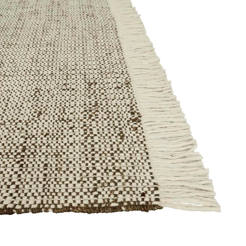 Close up o fthe olive green wool and jute floor rug, highlighting the fringe detail