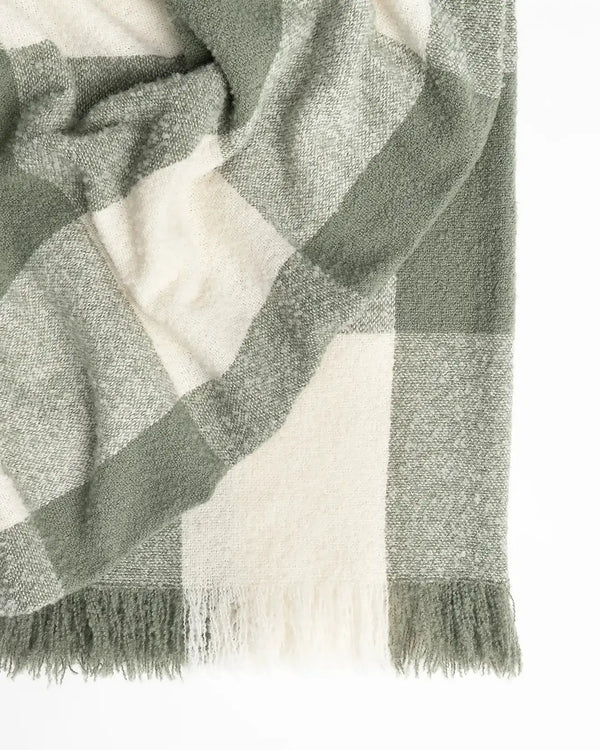 A green and white boucle wool throw blanket with fringe, by Weave Home nz