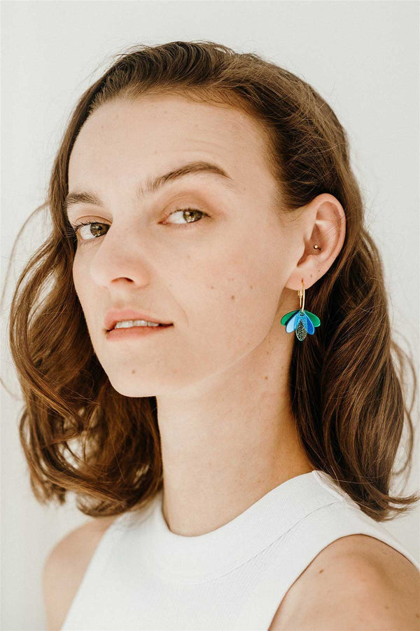 Cute everyday hoop earrings featuring blue acrylic, worn by a model