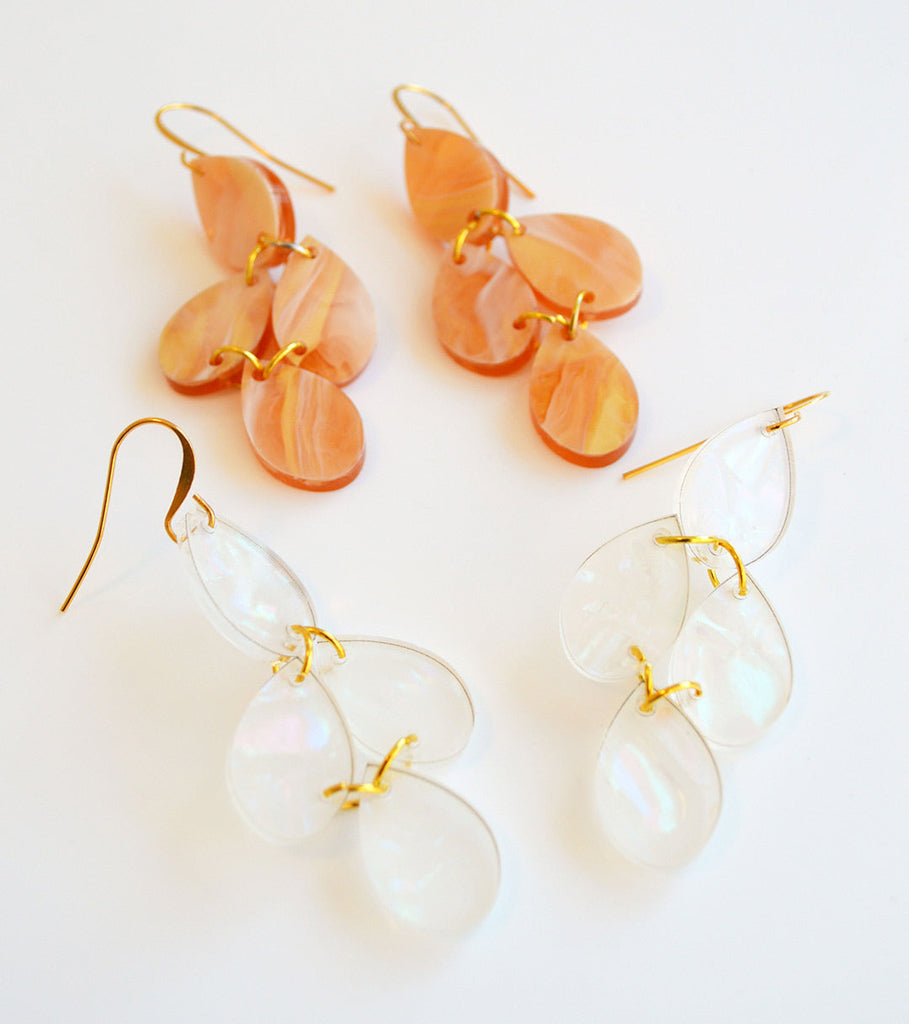 Clear pearlescent dangle earrings by Hagen + Co, shown alongside a peach pair
