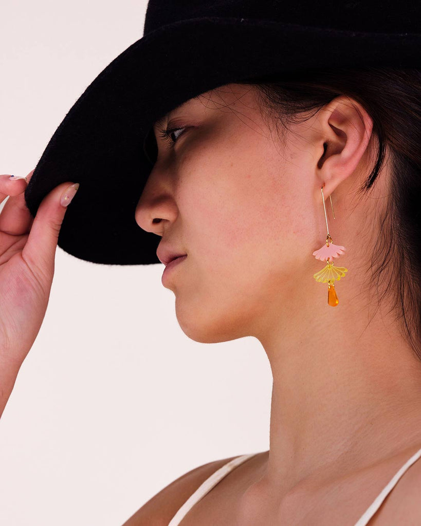 Stylish woman wearing delicate, sweet dangle earrings inspired by Japanese style and designs in a beautiful peach swirl acrylic, by Hagen + Co