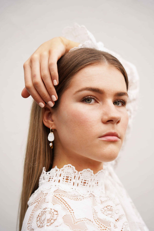 Elegant Hagen + Co earrings N featuring acrylic, glass beads, and a freshwater pearl charm, worn by a model