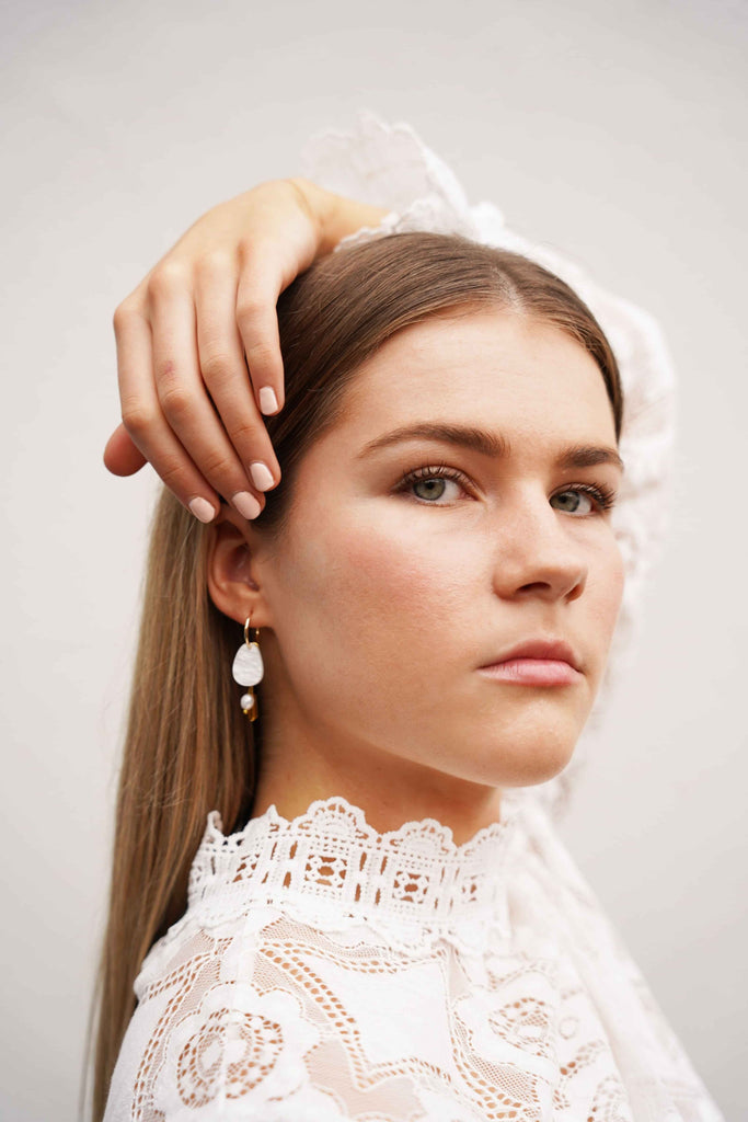 Elegant Hagen + Co earrings N featuring acrylic, glass beads, and a freshwater pearl charm, worn by a model