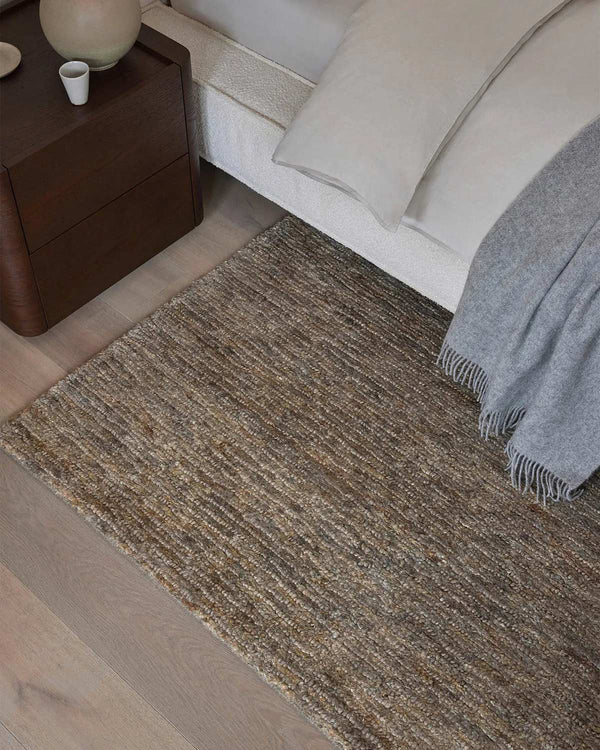 A bedroom with a beige taupe cool-toned floor rug made of 100% hand woven jute. 