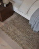 A bedroom with a beige taupe cool-toned floor rug made of 100% hand woven jute. 