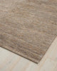 A taupe floor rug in hand knotted jute, with a high texture of alternating cut and looped pile. 