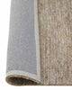 A textured jute floor rug in soft beige with the corner flipped up to show the durable cotton backing. 