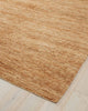A corner image of a natural warm brown floor rug made with textural jute fibres in a cut loop stitch. 