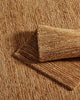 A natural jute mat and a floor rug in natural brown tones with loop and cut weaving. 