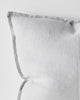A close up of the corner of a soft light grey cushion with a flanged edge, made with European linen.