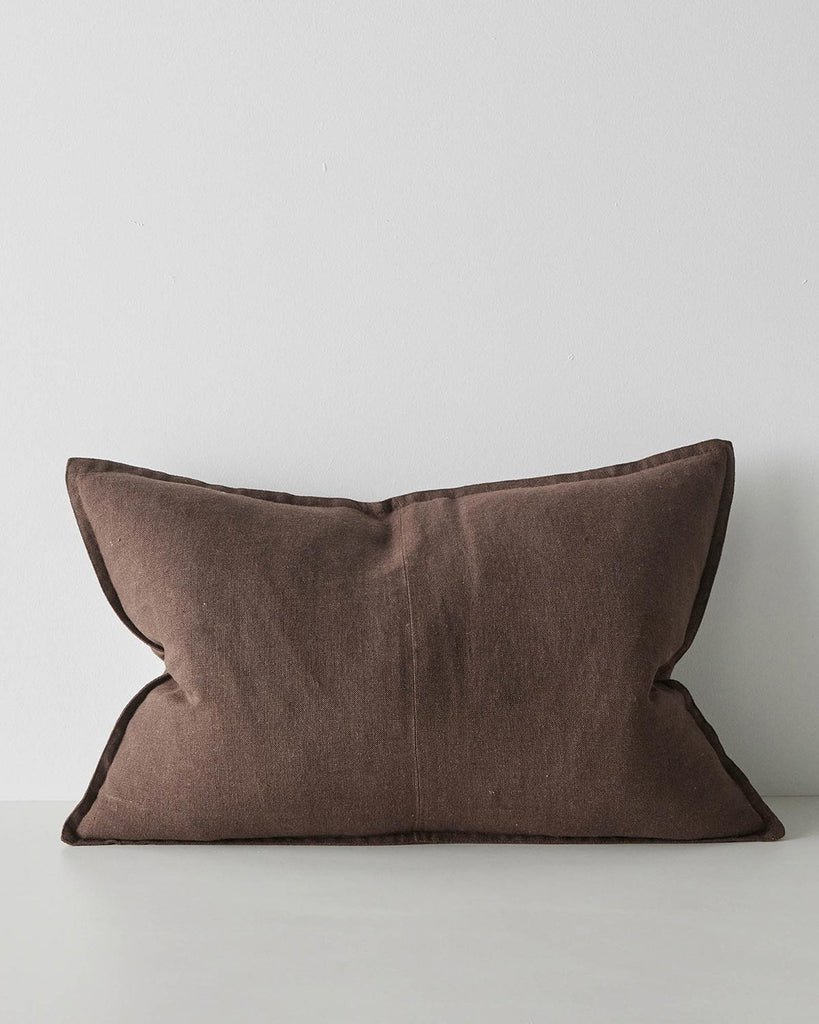 A lumbar cushion in a warm deep brown shade with a seam down the middle and flanged edges. 