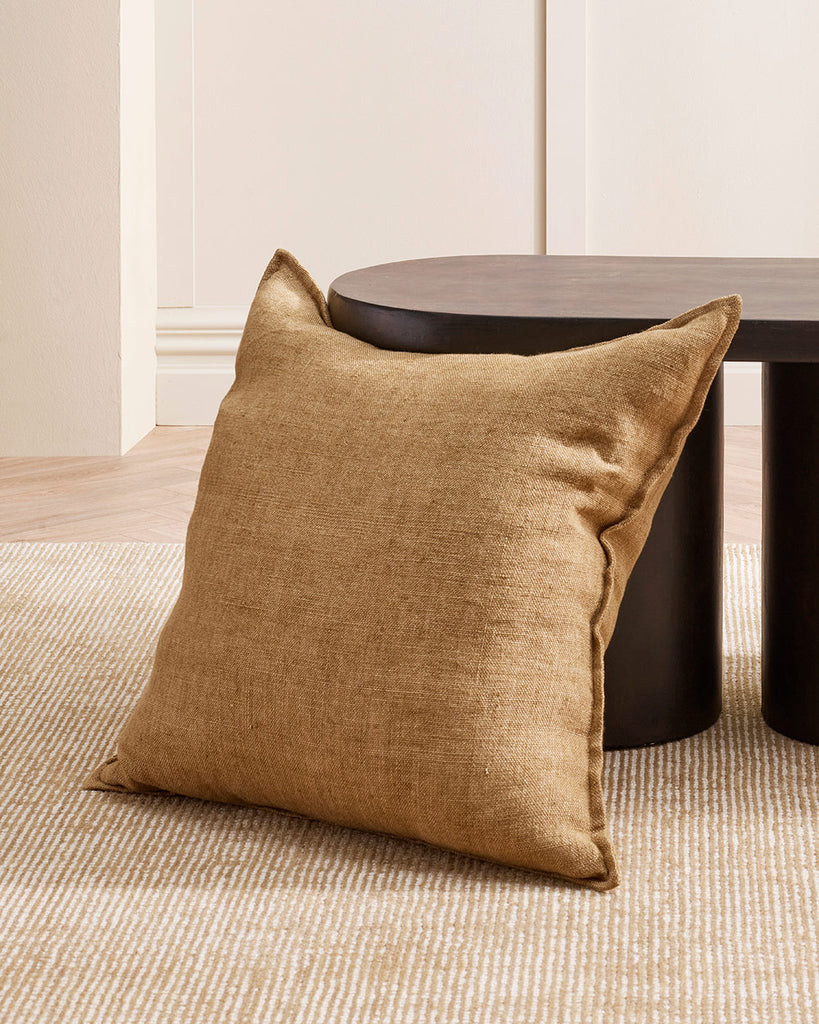 A soft yellow brown cushion, in textured linen with a soft flange edge, by Baya. 
