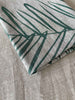 Close up of a folded handprinted linen tea towel 'Leaf Sage Green' by Smitten Design nz