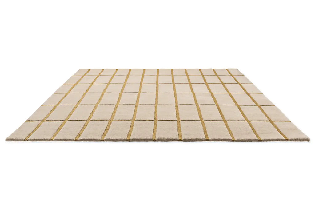 Perspective view of the Marimekko Tilliskivi wool floor rug in bronze yellow