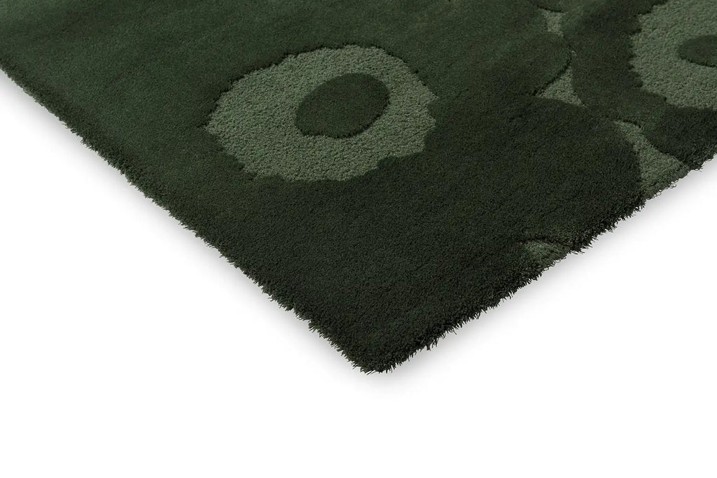 Corner close up of the Marimekko Unikko dark green wool floor rug