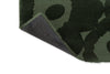 Close up of the Maimekoo Unikko dark green wool floor rug with corner folded to show underneath