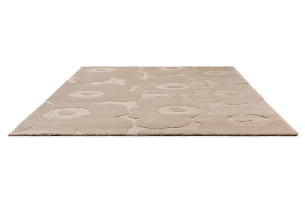 Full perspective view of Marimekko's iconic Unikko design features on this wool floor rug in a light beige colour.