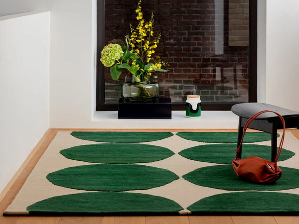 The Marimekko Isot Kivet rug in a rich green and calming cream; seen in a contemporary room