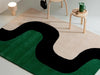 The Marimekko Seireeni green floor rug featuring an organic curve design, seen in a modern room