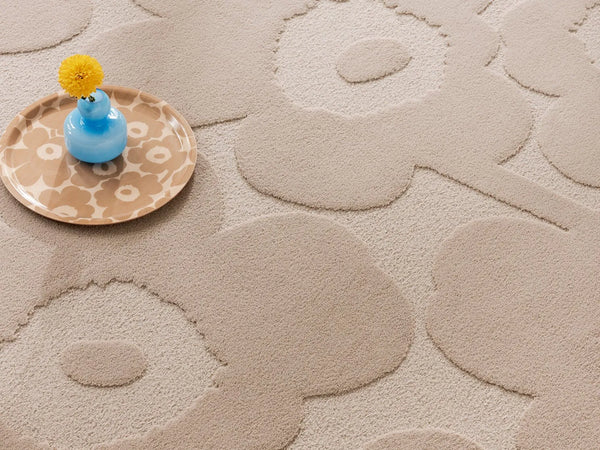 Marimekko's iconic Unikko design features on this wool floor rug in a light beige colour.