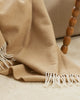 A detailed view of the twisted edging of the merino wool throw blanket in shade Sand. 