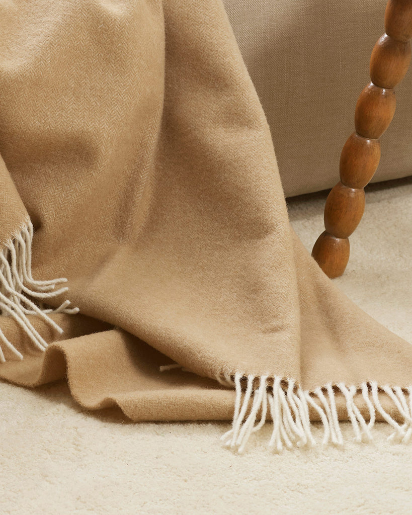 A detailed view of the twisted edging of the merino wool throw blanket in shade Sand. 