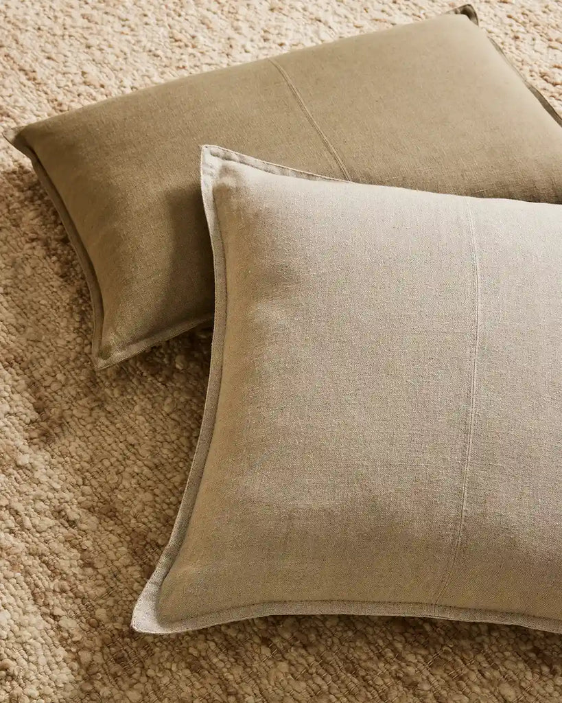 Two neutral linen cushions sitting on the wool boucle Henley floor rug by Weave nz