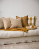 A selection of earthy-toned cushions by Baya arranged on a cream couch