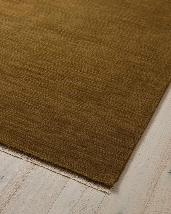 A stunning ochre floor rug in 100% wool with linear texturing and cream fringed edging. 