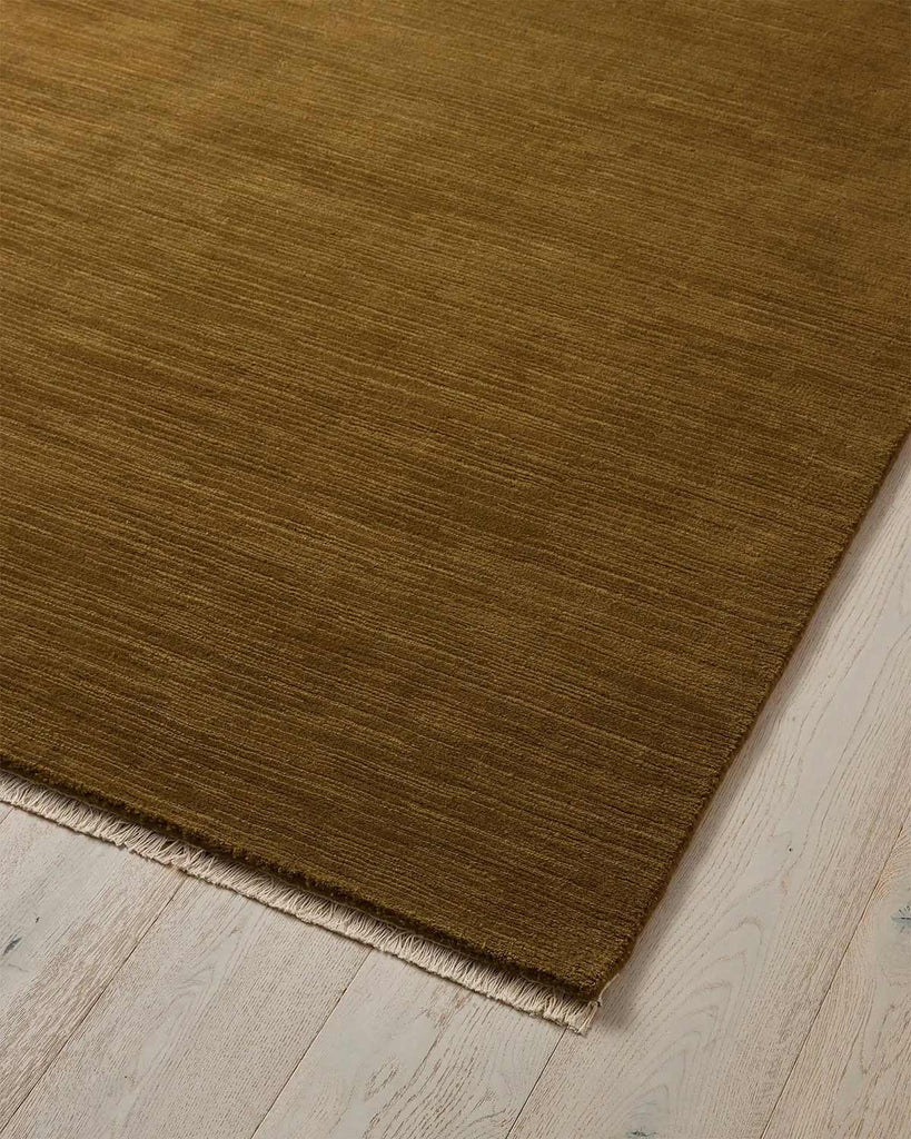 A stunning ochre floor rug in 100% wool with linear texturing and cream fringed edging. 