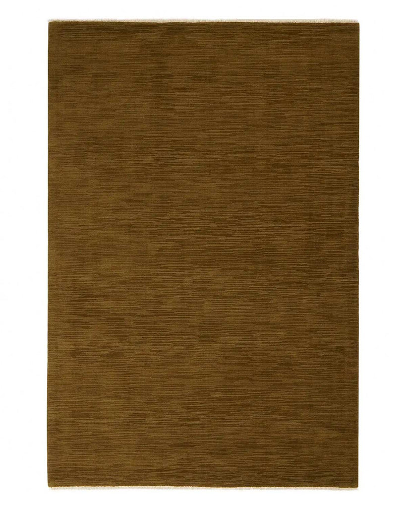 A full view of a deep brass toned floor rug in 100% NZ wool with off-white subtle fringing at the edges. 