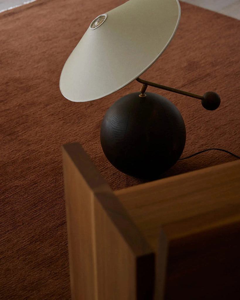 A modern living area with a deep rust red brown floor rug in 100% NZ wool. 