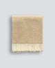 A beautiful NZ made throw blanket in 100% NZ wool, featuring a twill weave and trending ochre colour, shown folded with twisted fringe