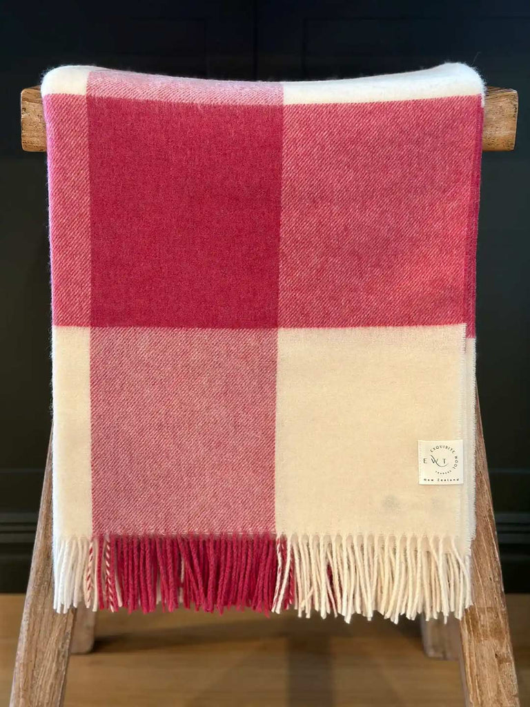 A pure NZ merino wool throw blanket in a pink and white check, by Exquisite Wool Blankets