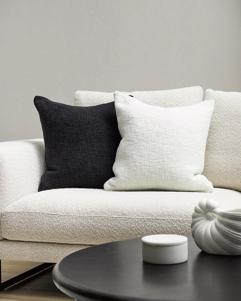 Black and white Baya cyprian cushions on a creamy white boucle couch