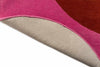 The red and pink round spot flower floor rug by Orla Kiely seen with edge folded to reveal underneath