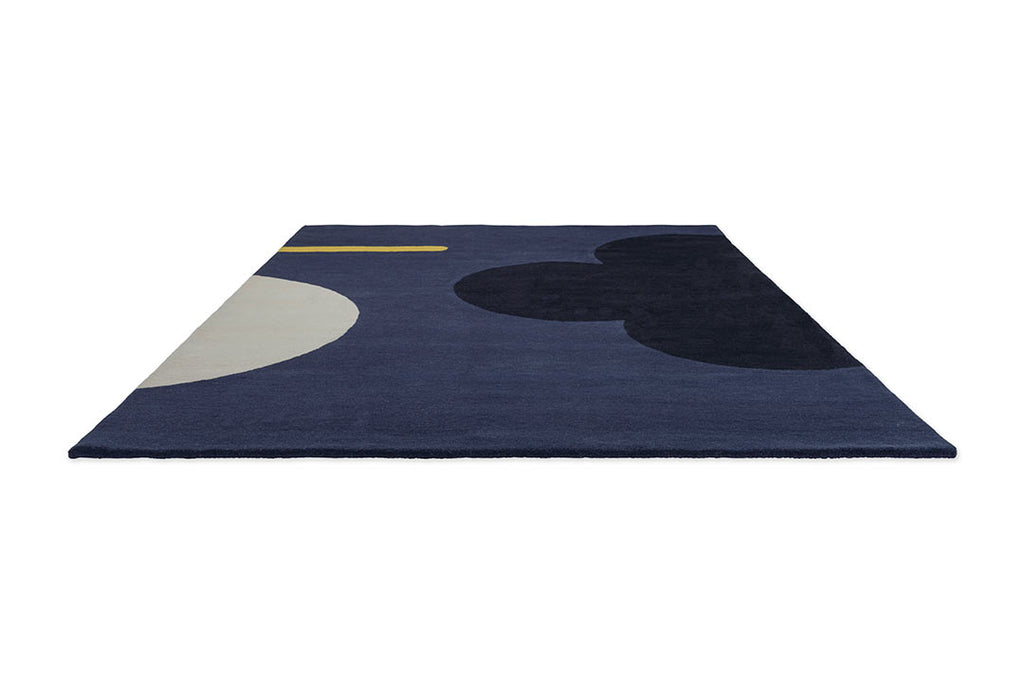 The Orla Kiely Geo Flower floor rug, in colour denim blue, seen in perspective