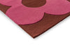 The Orla Kiely Sprig Stem floor rug in colour 'paprika' pink and red, seen close up from the corner