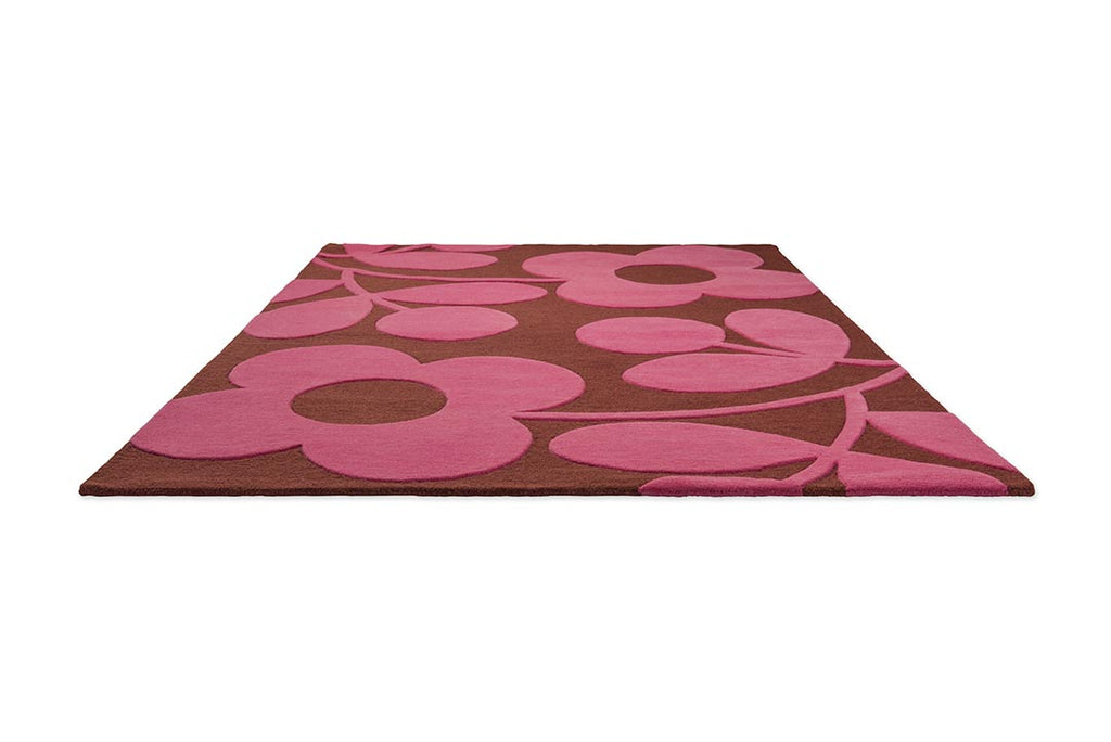 The Orla Kiely Sprig Stem floor rug in colour 'paprika' pink and red, seen in perspective