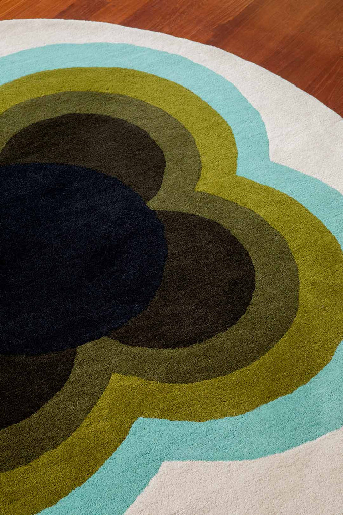 A close up of the Orla Kiely round Sunflower wool rug in olive green tones