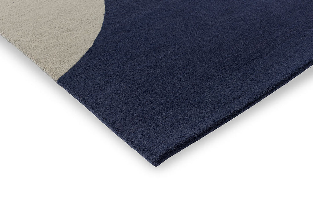 A close up corner view of the Orla Kiely Geo Flower floor rug, in colour denim blue