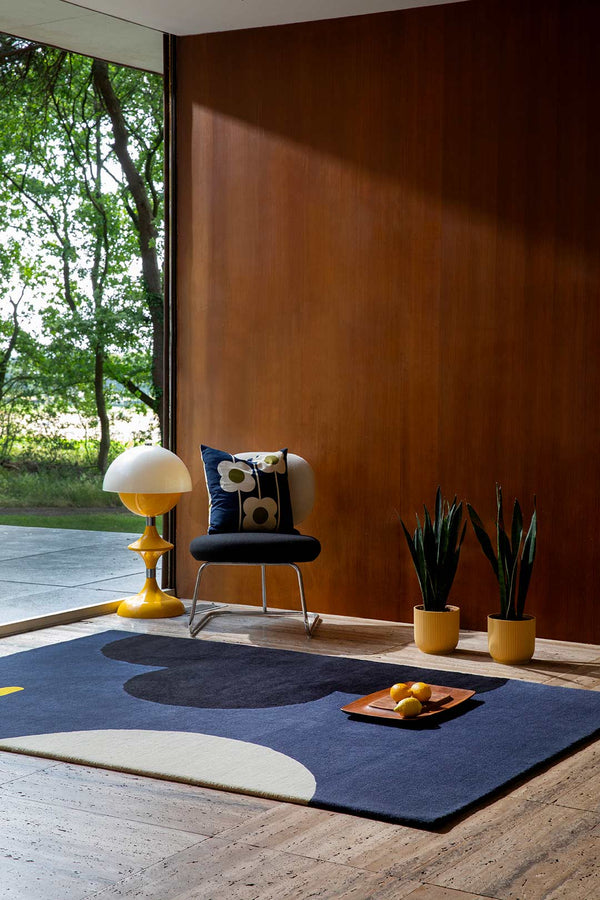 The Orla Kiely Geo-Flower rug in colour blue denim, seen in a stylish timber retro home.