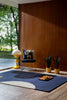 The Orla Kiely Geo-Flower rug in colour blue denim, seen in a stylish timber retro home.
