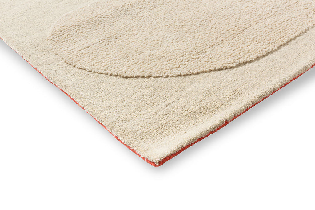 Orla Kiely designer floor rug 'Solid Stem Ecru' seen close up on the corner revealing a surprise orange trim underneath